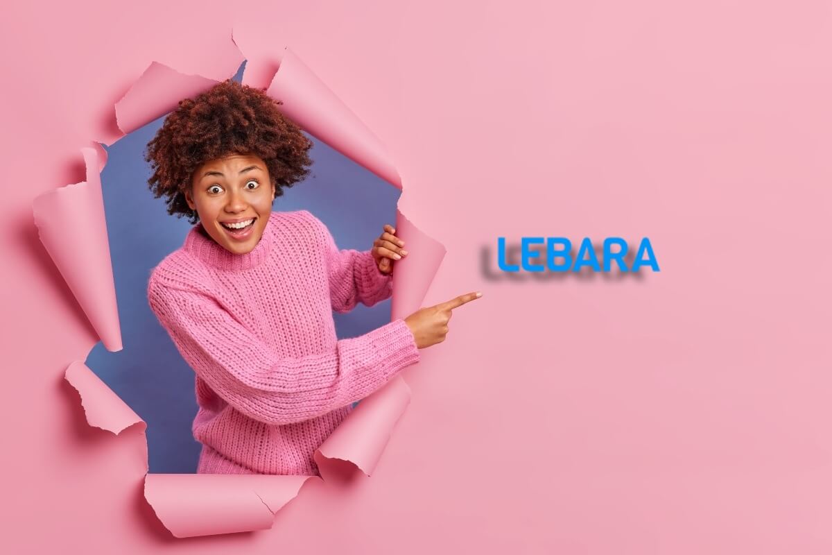 Femme troue le fond rose et montre du doigt le logo de Lebara, forfait le moins cher sur le réseau d'Orange